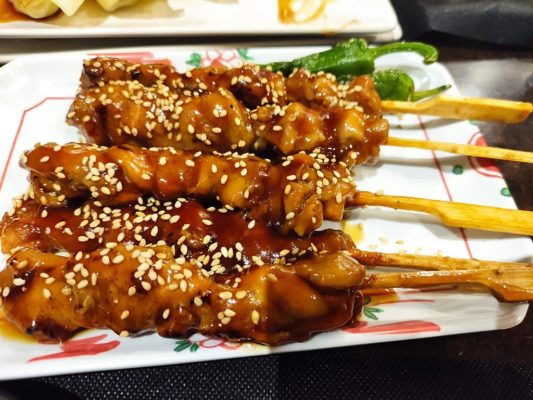 Brochetas de pollo yakitori asándose